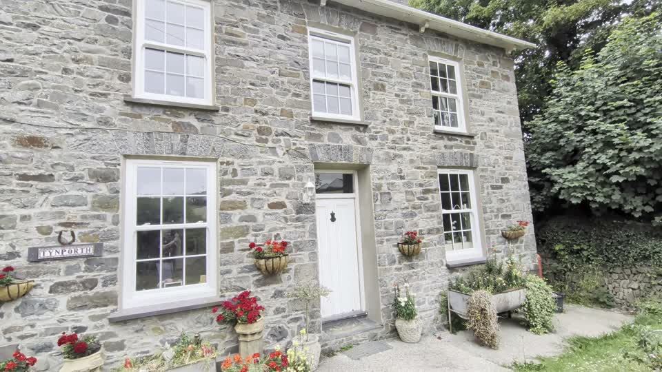 White sash-style windows fitted to the stone Aberaeron farmhouse